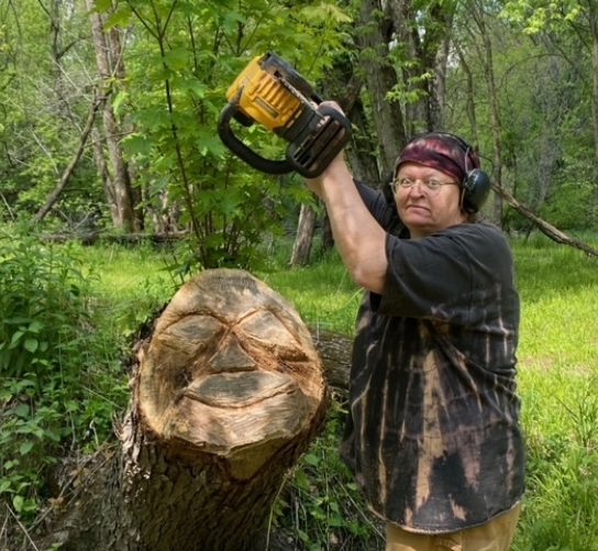 Ellie Erickson carving wood with a chainsaw for the DISCover Art Golf Disc Golf course in Reedsburg, WI.