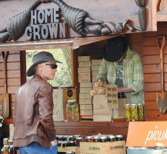 Food chain - a marketplace of food, art and ideas at Fermentation Fest 2021. A man in a hat buys some fermented concoctions from a local vender in Sauk County Wisconsin..